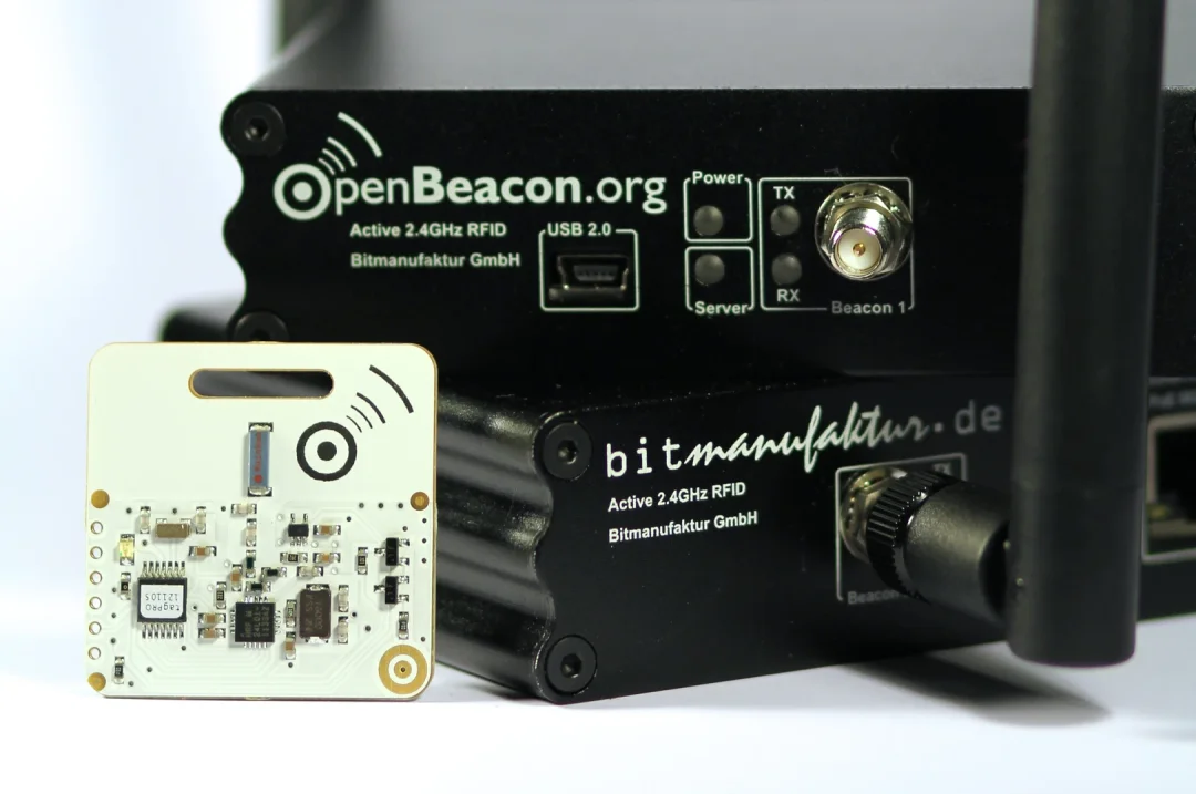 Black OpenBeacon Ethernet reader with antenna next to a white proximity tag