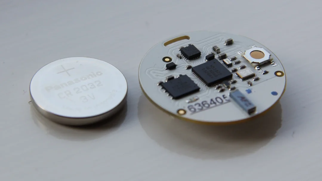 Top side of the nRF51 OpenBeacon tag next to a CR2032 coin cell