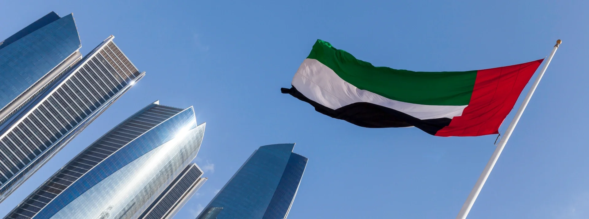 Flag of the United Arab Emirates flying in front of the Etihad Towers in Abu Dhabi
